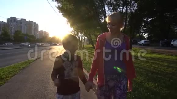 快乐的妈妈和儿子一起在日落时慢动作视频的预览图