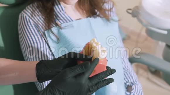 特写慢镜头拍摄稳定的医生牙科医生戴着无菌医疗手套手里拿着一个人体模型视频的预览图