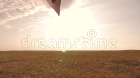 日落时分一个男孩在田野里跑扔了一架纸飞机幸福孩子的概念视频的预览图