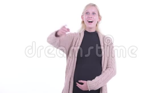 年轻的金发孕妇手指着视频的预览图