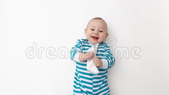 穿着蓝色条纹连衣裙的微笑宝宝玩纸船视频的预览图