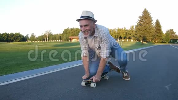 公园里快乐的老人膝盖上滑板视频的预览图