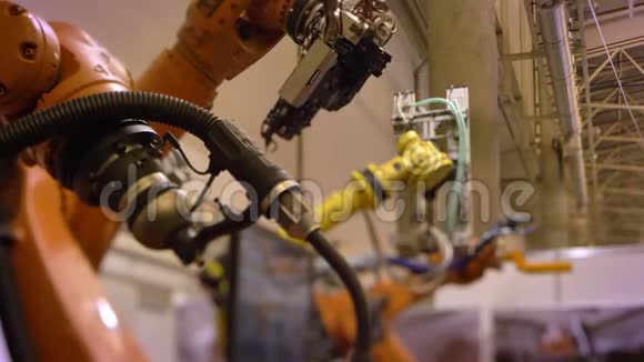 两个自动机器人手臂在工厂背景下的特写镜头视频的预览图