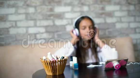 耳机里的模糊女孩在电话里唱歌听音乐用免费的复制空间做指甲视频的预览图