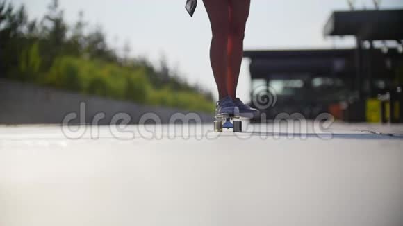 女孩骑着滑板经过镜头在腿的框架穿运动鞋视频的预览图