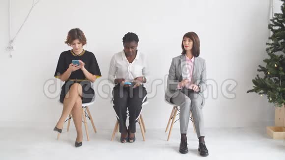 三个女孩坐在椅子上等待面试视频的预览图