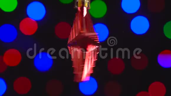 圣诞红星玩具正在旋转特写装饰与新年树灯闪烁的背景视频的预览图