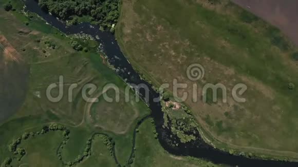 河的顶部景色两岸环绕着树木和草地从顶部空中俯瞰视频的预览图