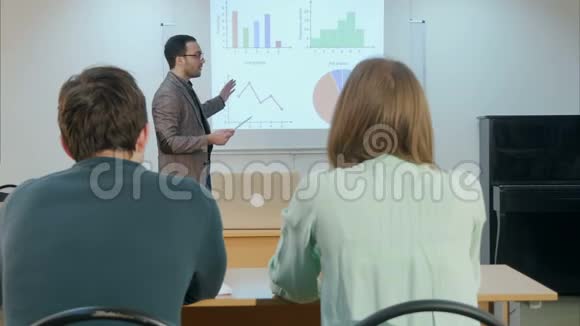 男学生举手坐在桌子上问老师一个问题视频的预览图