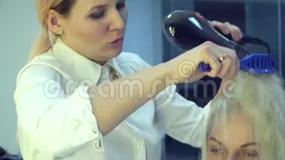 美容院理发店斯特里斯特把头发给他的客户理发师做造型发特写镜头视频的预览图