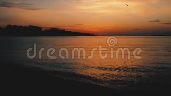 美丽的日落越过大海在黑暗的水面上红色的戏剧性日落太阳天空大海海浪和沙子视频的预览图