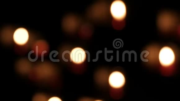 美丽模糊的红色教堂蜡烛在特殊的壁龛祈祷在一个天主教寺庙的黑色背景视频的预览图
