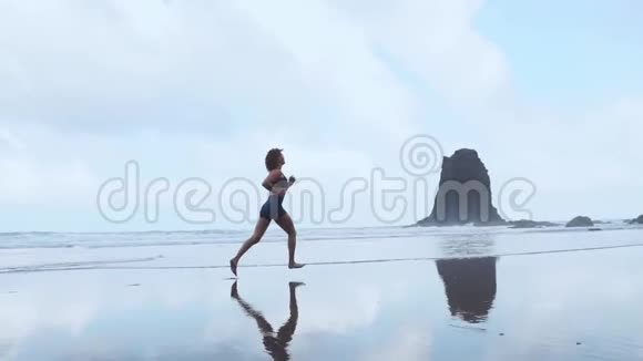 赤足运动的女孩苗条的身体沿着海水在游泳池冲浪以保持健康和健康海滩背景视频的预览图