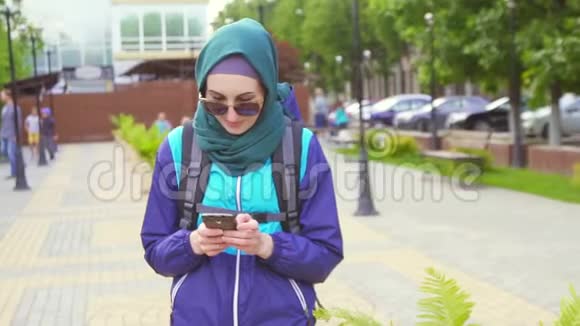 公园里带着智能手机背包的可爱旅游女孩的画像视频的预览图