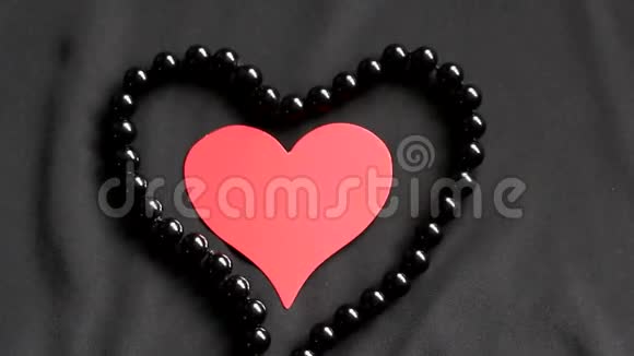 红色的心在黑色的背景和黑色的珍珠视频的预览图