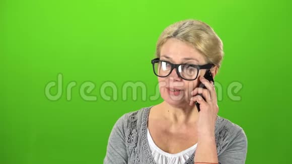 戴眼镜的家庭主妇在打电话绿色屏幕视频的预览图