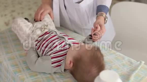 一位女医生在医院的一张换洗的桌子上检查一个新生儿视频的预览图