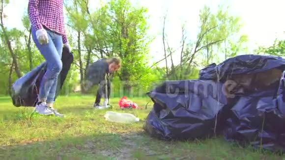 妈妈和十几岁的女儿在公园概念里用塑料袋收集垃圾视频的预览图