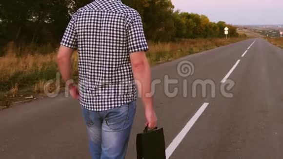 年轻的男企业家走在路上手里拿着一个黑色公文包手里拿着文件视频的预览图