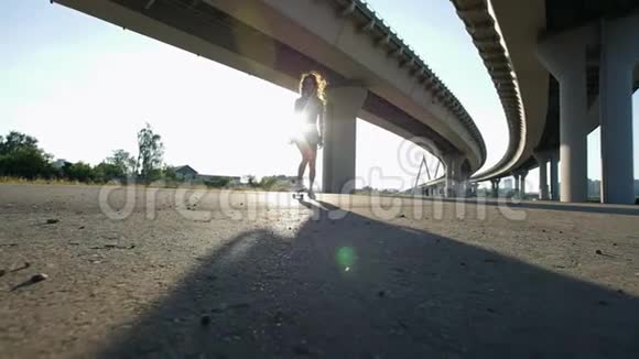 夜晚可爱的女孩在桥下骑着滑板阳光普照视频的预览图