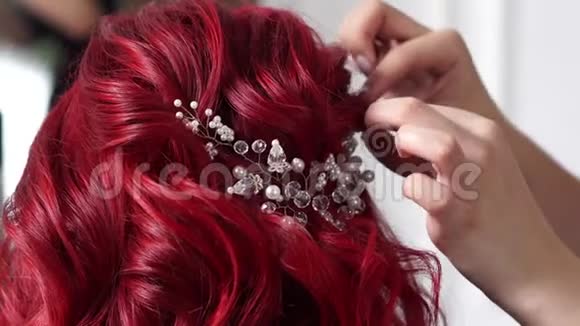 理发师的手把珠宝系在新娘头发上视频的预览图