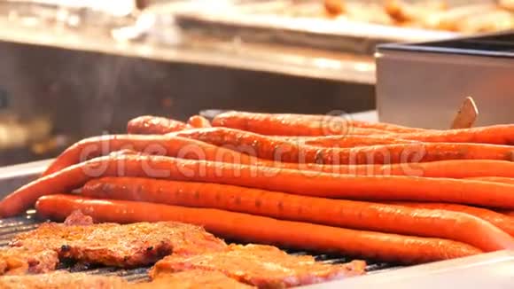 巨大的半米长的红色香肠和肉排上面有蒸汽正在圣诞节市场上烤传统视频的预览图