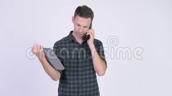 一张快乐的时髦男人用电话和数码平板电脑拍摄的照片视频的预览图