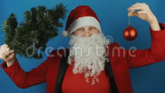 2019年新年男人就像一个圣诞老人带着圣诞树和蓝色背景上的红色球宝玩具视频的预览图