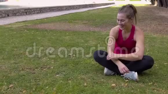 女运动员在公园的草坪上休息视频的预览图