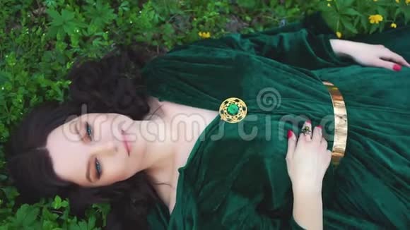 穿着翡翠雨衣的女巫春天森林里长着卷发的魔术师视频的预览图