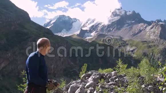 一个人站在山峰前用手指着它们视频的预览图