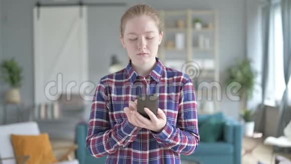 年轻女子站着用智能手机视频的预览图