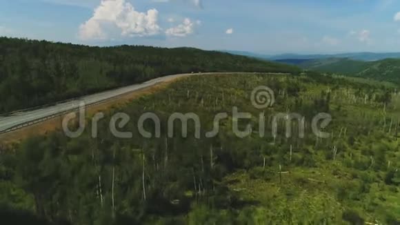 4K无人驾驶飞机射击飞越一条道路发现一条道路在一个美丽的森林与汽车移动视频的预览图