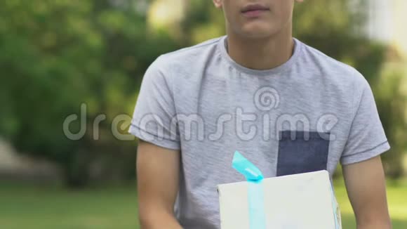 十几岁的男孩抱着礼物等着女朋友担心第一次约会视频的预览图