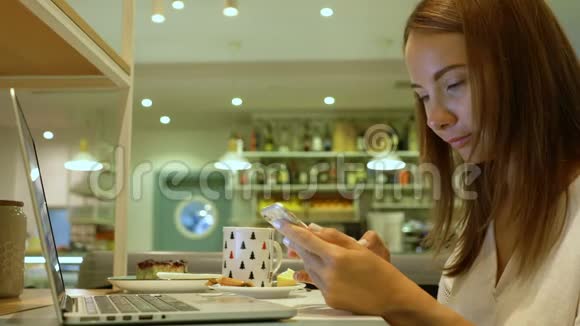 可爱的女人在咖啡馆里用笔记本视频的预览图