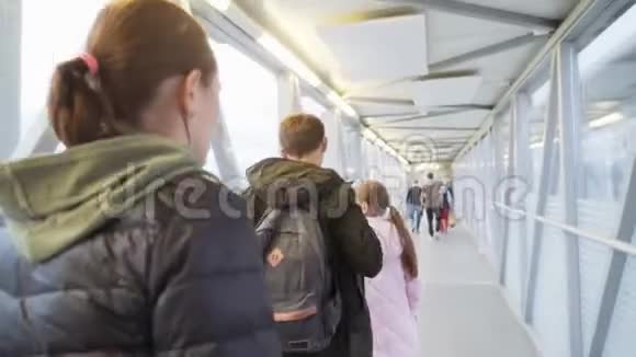 一个女人和她的女儿和儿子在一个伸缩坡道上到机场用手射击4k视频的预览图