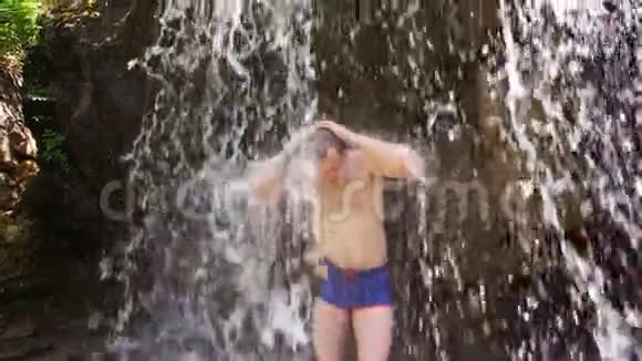人在冰冷的瀑布中沁人心脾旅行者在大瀑布里享受水视频的预览图