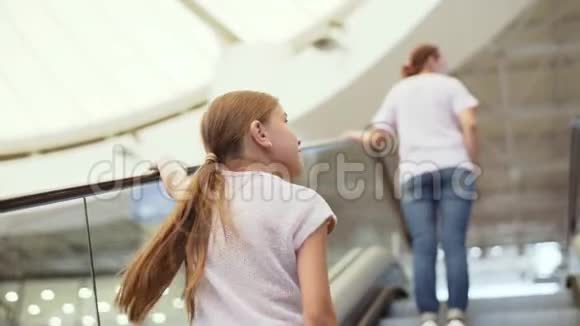 妈妈和女儿在机场的自动扶梯上视频的预览图