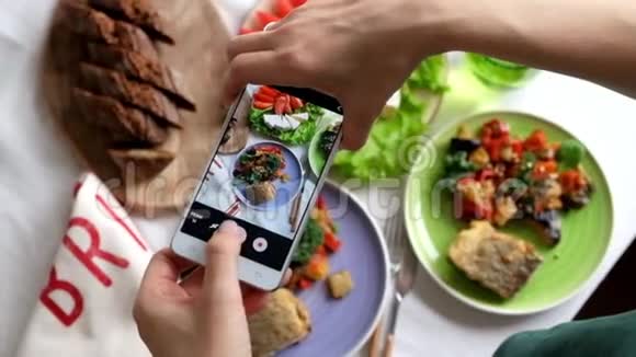女人用智能手机拍照食物上面的风景视频的预览图