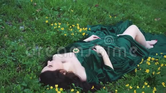 穿着翡翠雨衣的女巫春天森林里长着卷发的魔术师视频的预览图