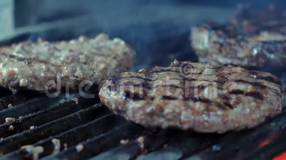 烤三个汉堡夹片的特写镜头烟雾来自热煤视频的预览图