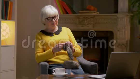 老年妇女学习用笔记本电脑编织视频的预览图