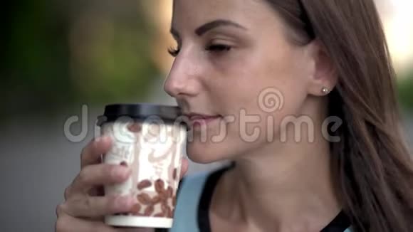 美丽的白种人年轻女人在街上喝外卖咖啡街上漂亮的女孩带着咖啡微笑视频的预览图