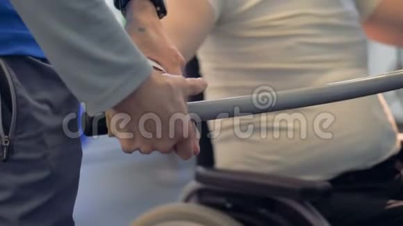 一个人正在帮助调整一个残疾人手中的酒吧视频的预览图
