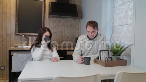 漂亮的男人和女人在厨房里喝茶在现代的内部视频的预览图