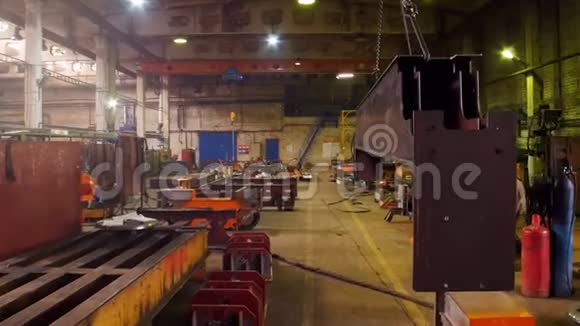 一个建筑工厂一台起重机吊在一个大铁上然后把它移到建筑工厂视频的预览图