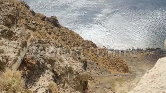 陡峭悬崖下阳光明媚的大海站在高处看风景的人视频的预览图