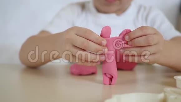 孩子们创造力这个孩子在桌子特写上用粉红色的面团拼成图形可爱的孩子塑料视频的预览图