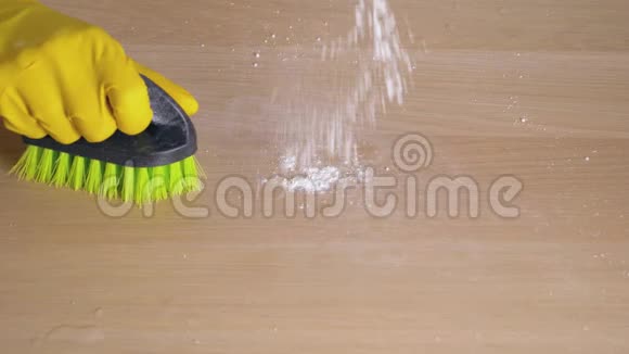 家庭主妇用橡皮手套用刷子用清洁粉擦拭脏桌子视频的预览图
