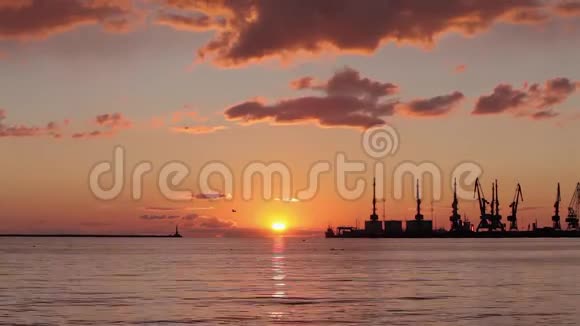 海港五彩缤纷的日落背景中的太阳落在地平线上视频的预览图